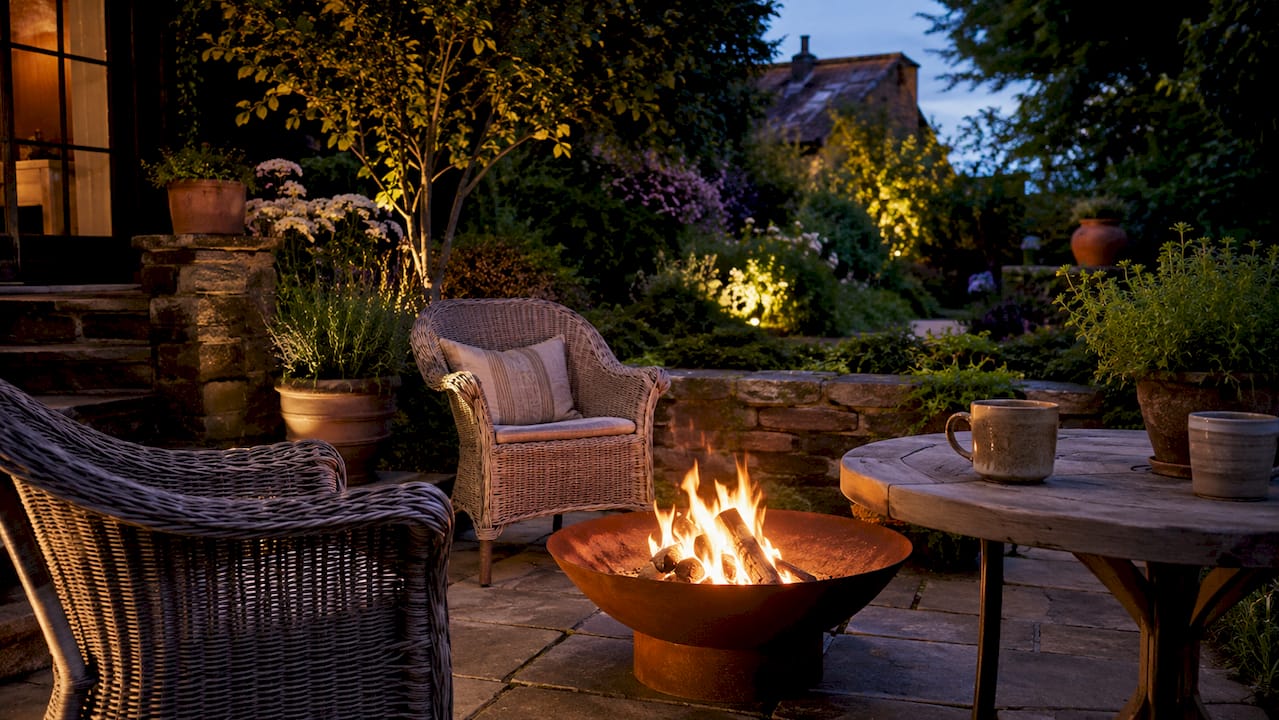 Glowing fire pit in British garden at dusk