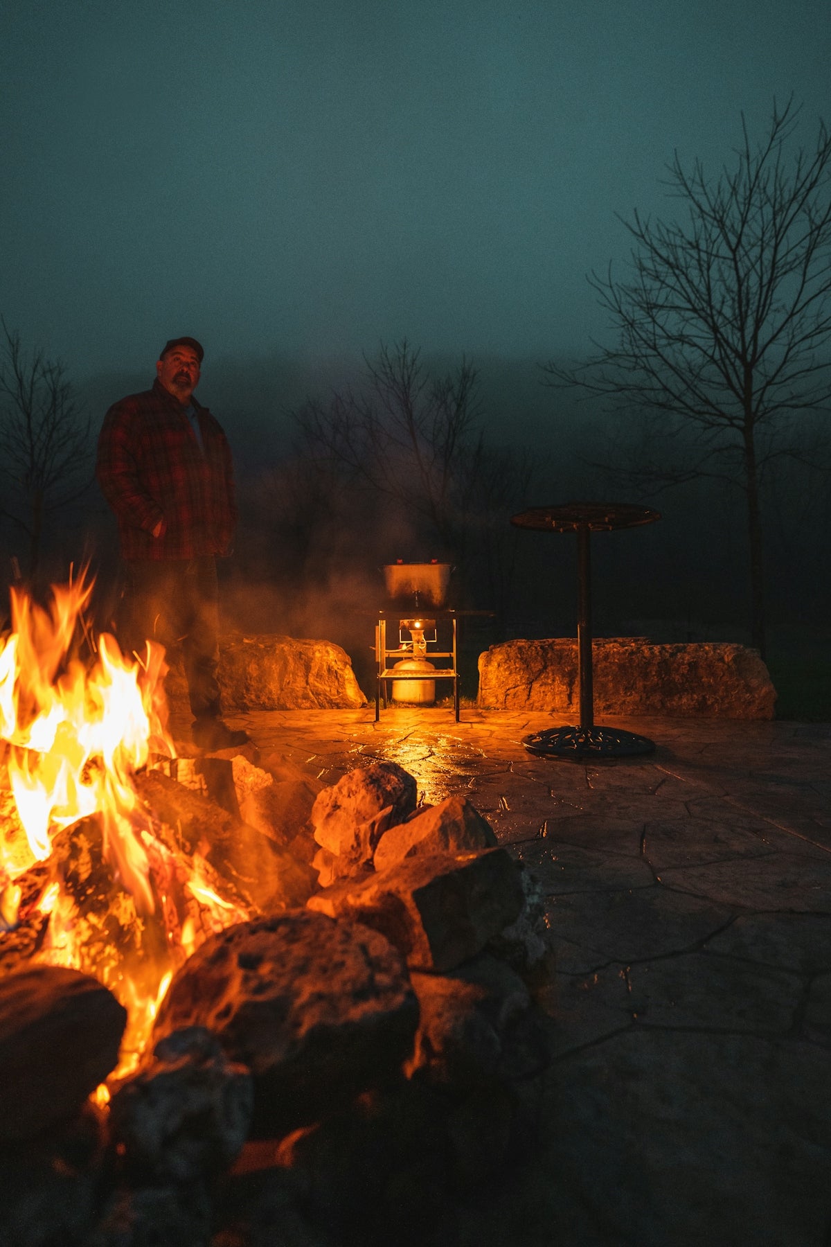 a man standing in front of a fire pit